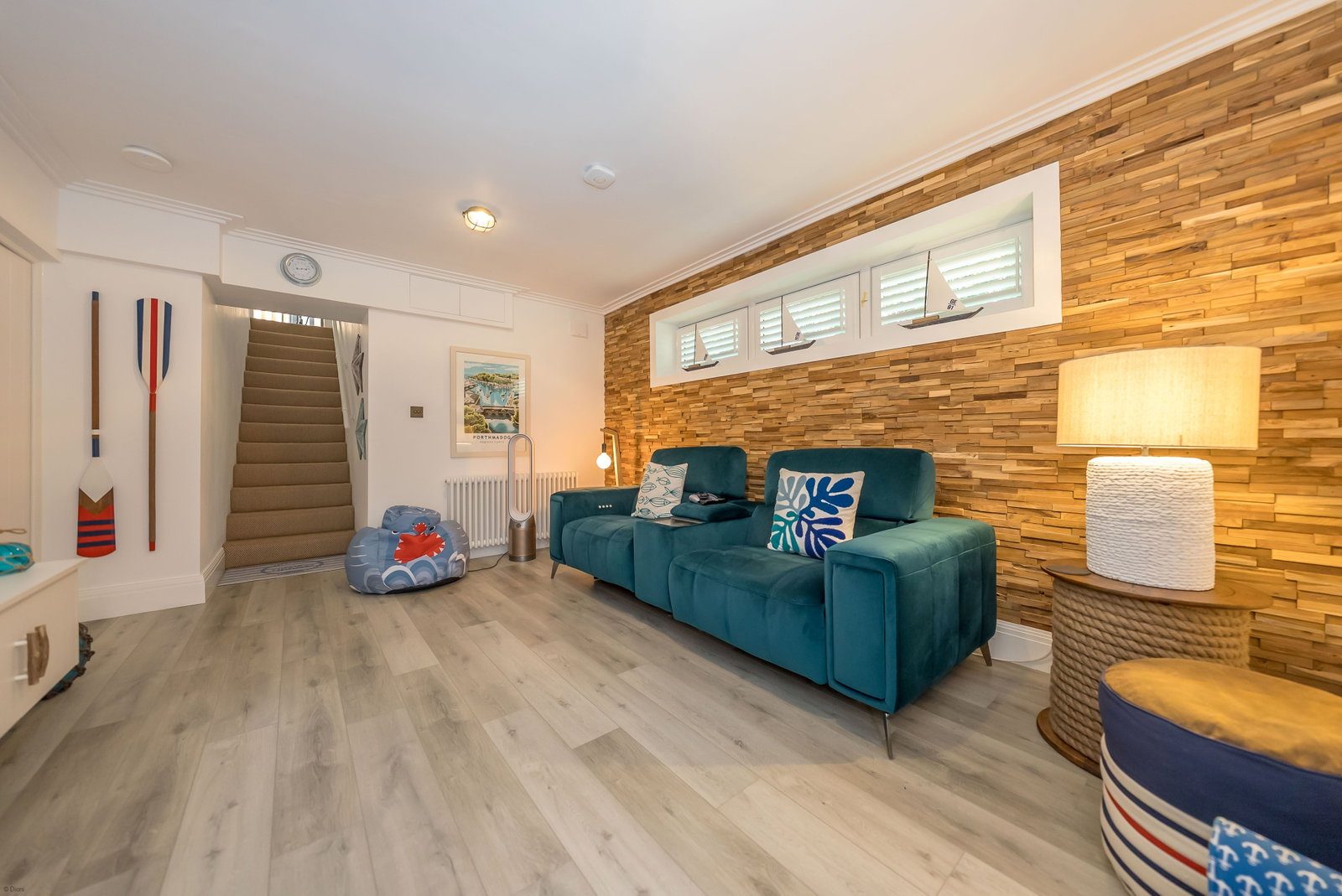 Cinema snug with teal sofa and timber feature wall